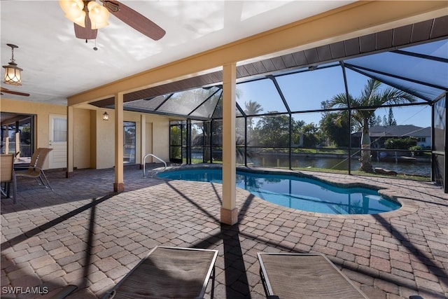 view of swimming pool with a lanai, a water view, ceiling fan, and a patio area