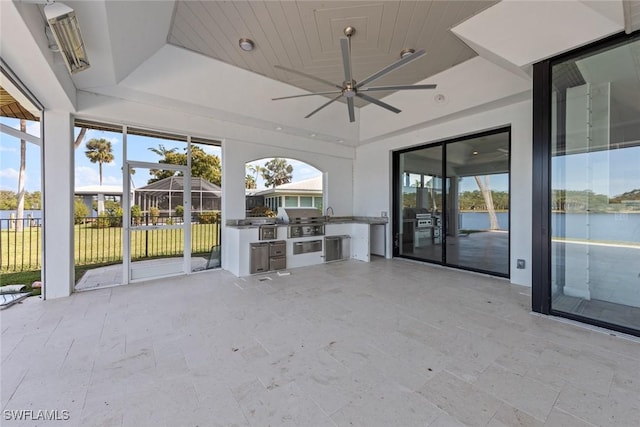 unfurnished sunroom featuring a healthy amount of sunlight, a water view, ceiling fan, and wooden ceiling