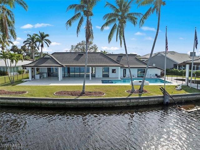 back of house with a yard, a water view, and a patio