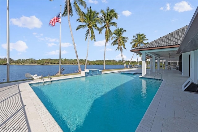 view of swimming pool with a patio area, ceiling fan, and a water view