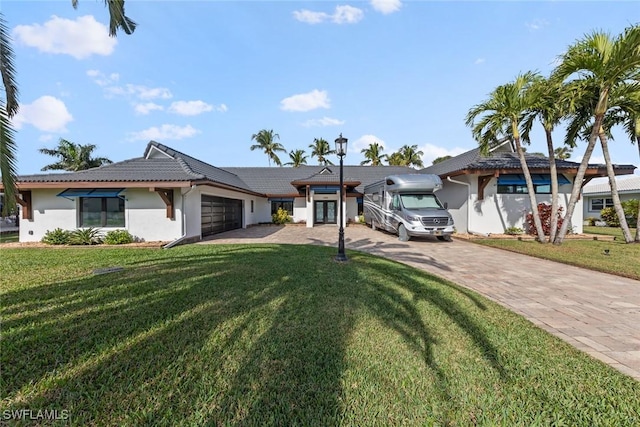 view of front of house featuring a front lawn and a garage