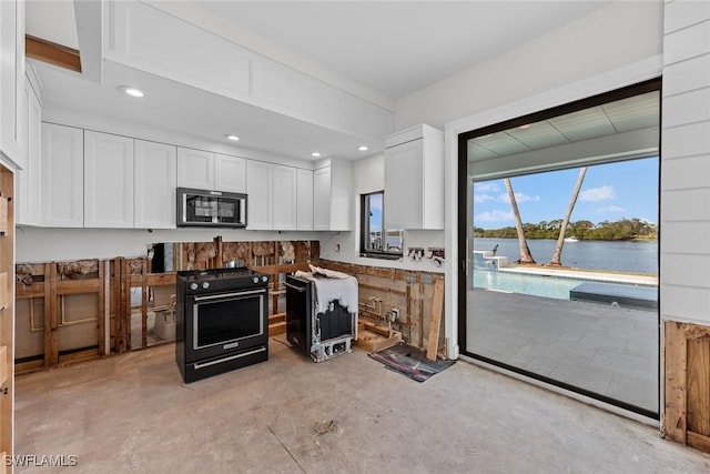 kitchen featuring black range oven, a water view, and white cabinetry