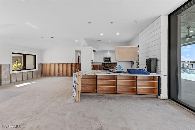 kitchen with black stove and white cabinetry