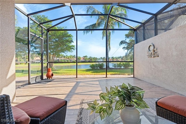 view of patio / terrace featuring a water view and glass enclosure