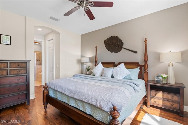 bedroom with wood-type flooring, ensuite bath, and ceiling fan