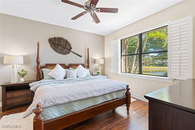 bedroom featuring ceiling fan, a water view, and dark hardwood / wood-style floors