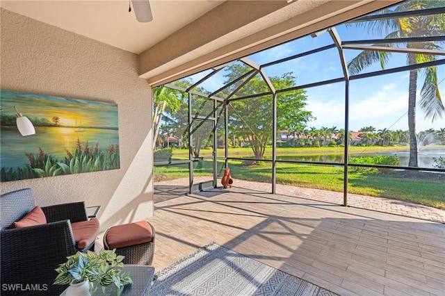 view of patio / terrace with glass enclosure, ceiling fan, and a water view