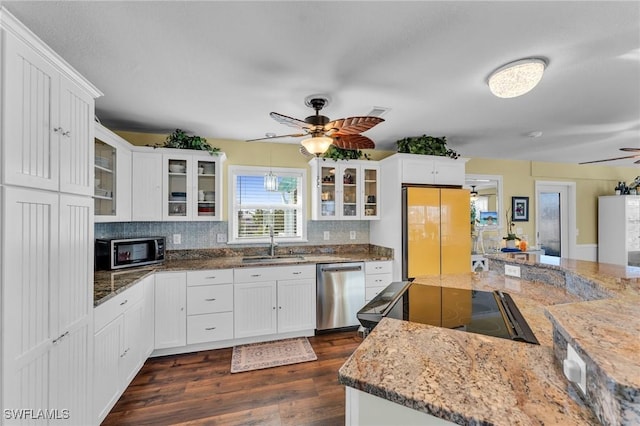 kitchen featuring white cabinetry, sink, tasteful backsplash, light stone counters, and appliances with stainless steel finishes