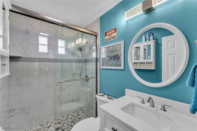 bathroom with vanity, a shower with shower door, and toilet