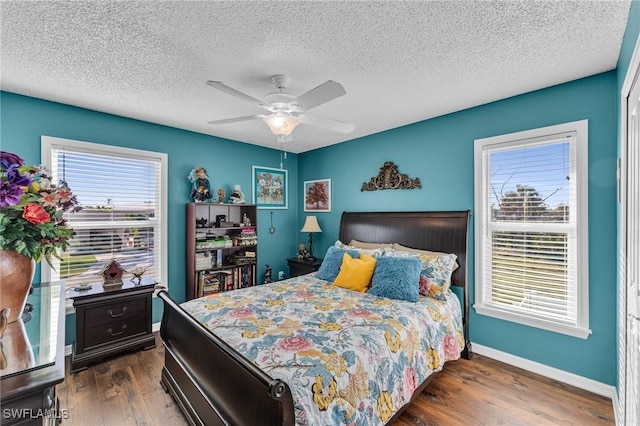 bedroom with a textured ceiling, dark hardwood / wood-style flooring, and ceiling fan