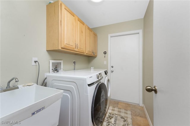 clothes washing area with sink, cabinets, and independent washer and dryer