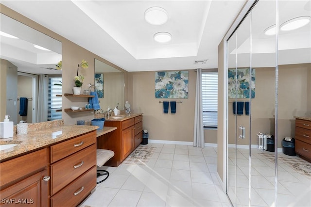 bathroom featuring tile patterned flooring, vanity, a raised ceiling, and a shower with shower door