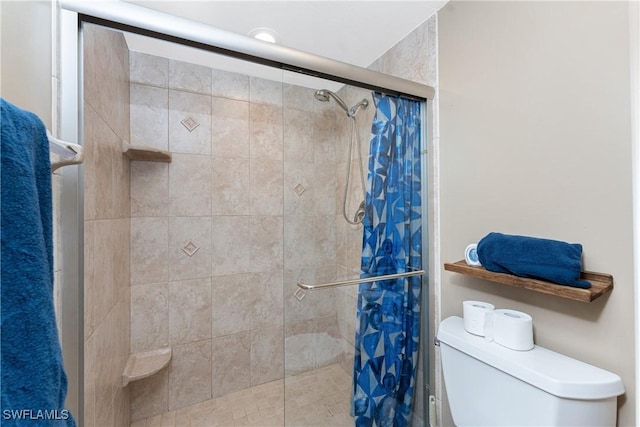 bathroom featuring toilet and a shower with shower door