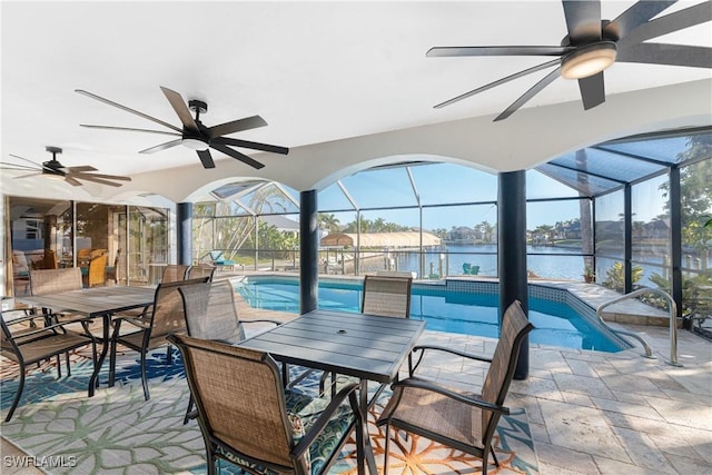 view of patio / terrace featuring a lanai and a water view