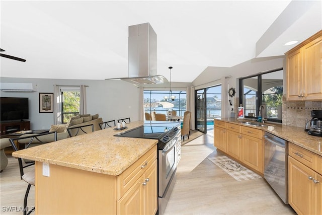 kitchen with island exhaust hood, appliances with stainless steel finishes, a kitchen breakfast bar, a wall unit AC, and hanging light fixtures