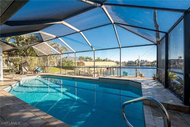 view of swimming pool with glass enclosure, a water view, and a patio