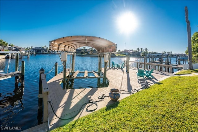 view of dock with a yard and a water view