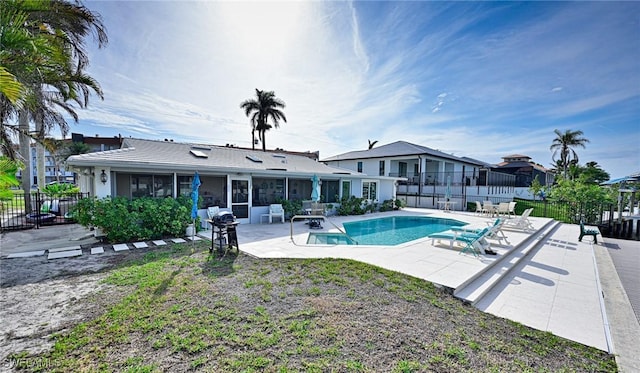 view of swimming pool featuring a grill, a patio, and a sunroom