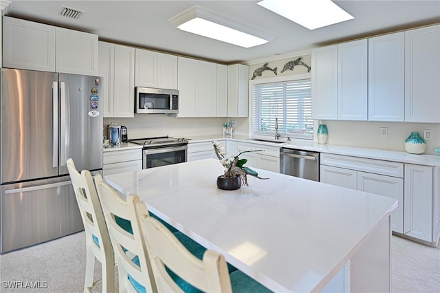 kitchen with white cabinets, a center island, and appliances with stainless steel finishes