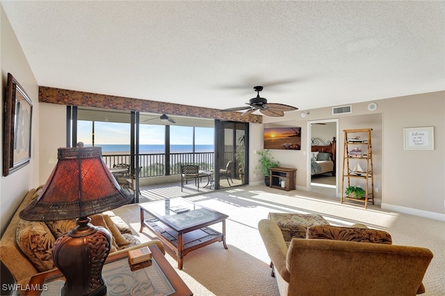 carpeted living room with a textured ceiling and ceiling fan