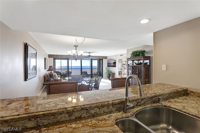 kitchen with ceiling fan with notable chandelier and sink