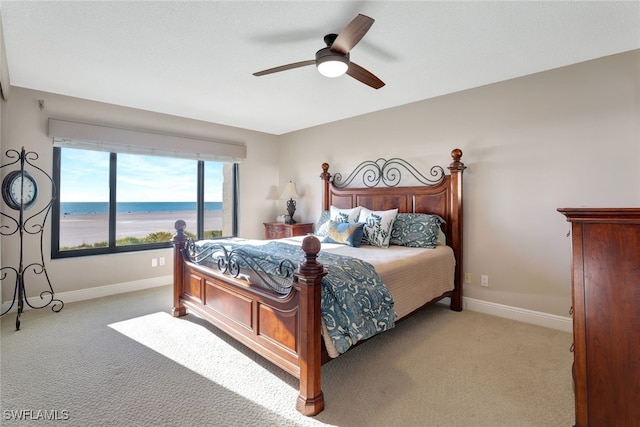 bedroom featuring carpet, a water view, and ceiling fan