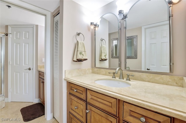 bathroom with tile patterned flooring, vanity, and a shower with shower door