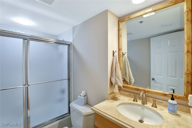 full bathroom with vanity, bath / shower combo with glass door, and toilet