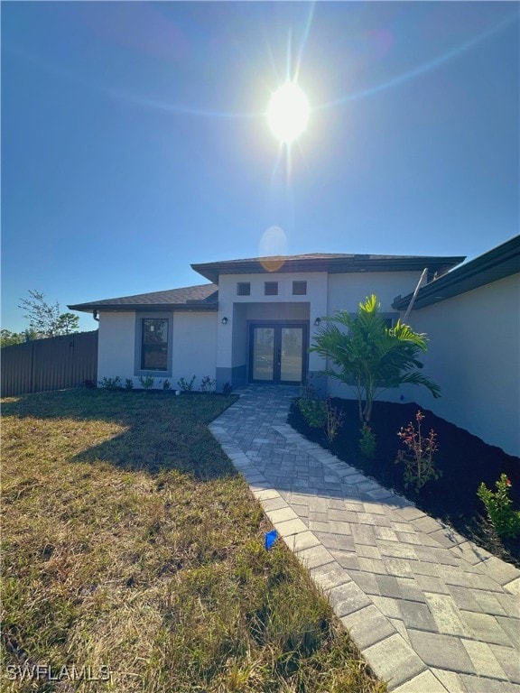 view of front of property with a front lawn and french doors