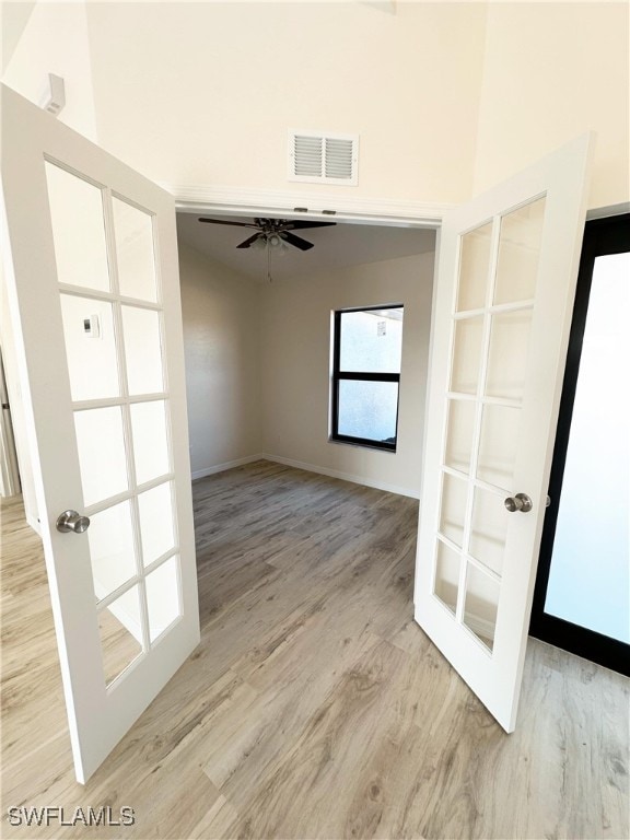 spare room with ceiling fan, french doors, and light hardwood / wood-style floors