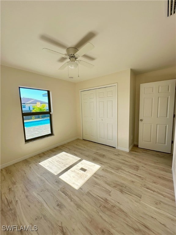 unfurnished bedroom with ceiling fan, a closet, and light hardwood / wood-style flooring