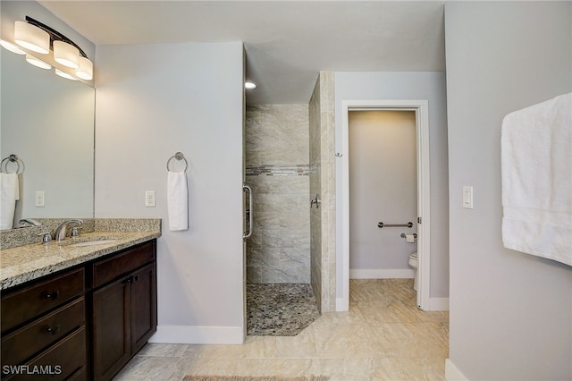 bathroom with vanity, toilet, and tiled shower