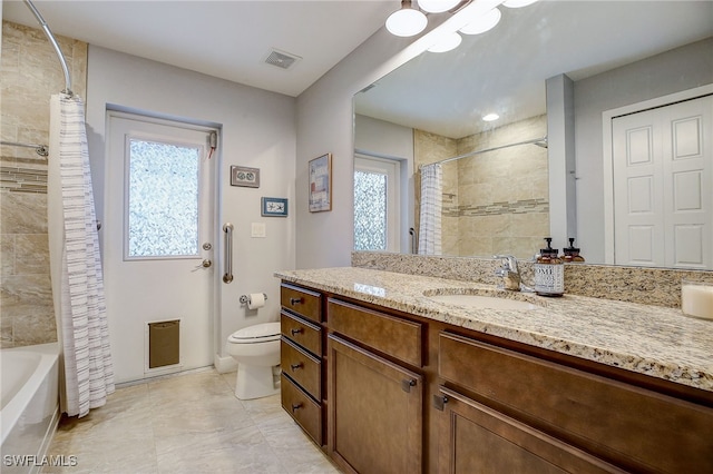 full bathroom featuring shower / bath combo, vanity, and toilet