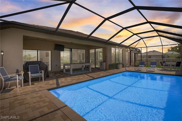 view of pool featuring glass enclosure and a patio area