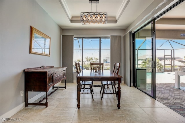 dining space featuring a tray ceiling and ornamental molding