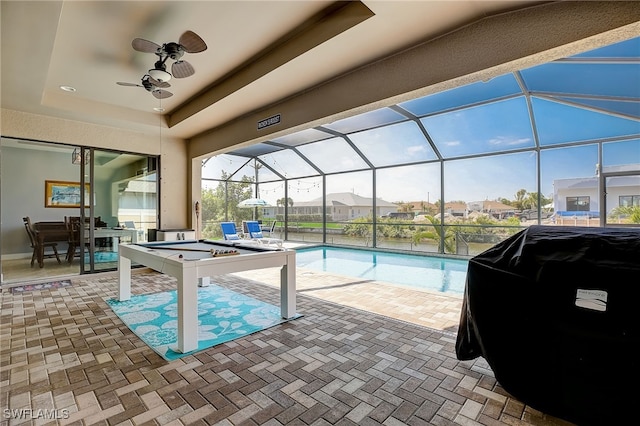 view of swimming pool with ceiling fan, a lanai, and a patio