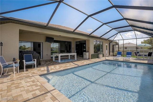 view of swimming pool featuring glass enclosure and a patio area