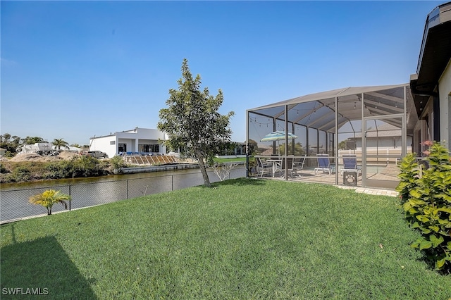 view of yard featuring a lanai, a water view, and a patio