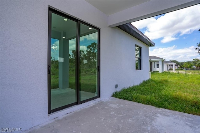 view of home's exterior featuring a patio and a lawn