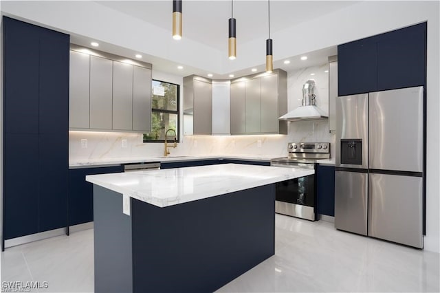 kitchen with sink, a center island, wall chimney range hood, decorative light fixtures, and appliances with stainless steel finishes