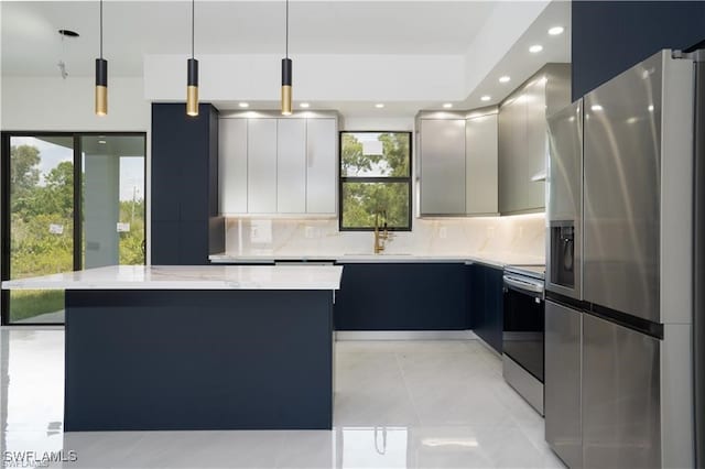 kitchen featuring sink, pendant lighting, decorative backsplash, a kitchen island, and appliances with stainless steel finishes