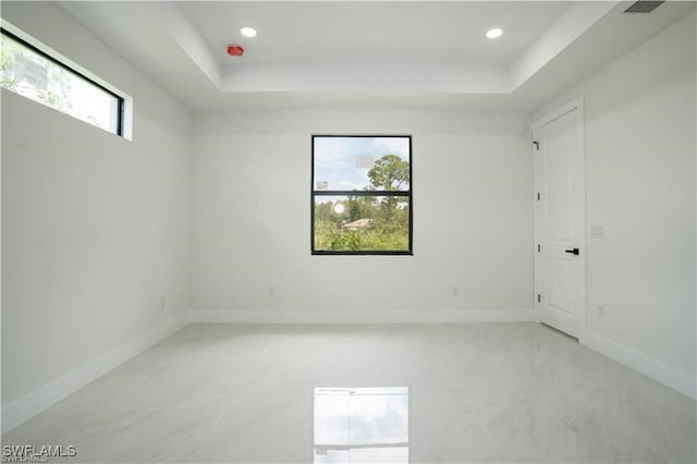 empty room featuring a raised ceiling