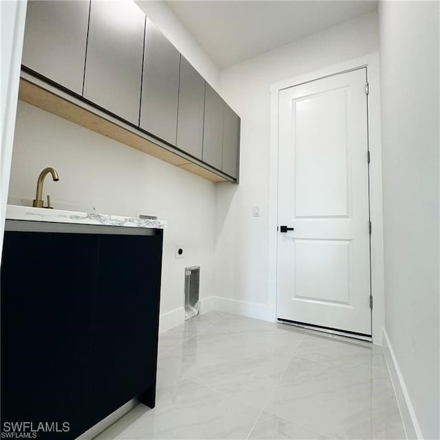 laundry room with electric dryer hookup and cabinets