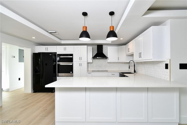 kitchen featuring black appliances, white cabinets, wall chimney exhaust hood, tasteful backsplash, and kitchen peninsula