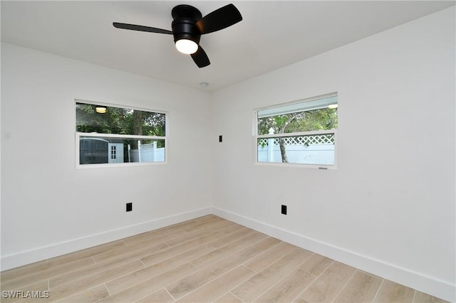 empty room featuring ceiling fan, plenty of natural light, and light hardwood / wood-style floors