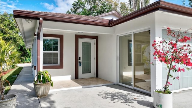 view of exterior entry featuring a patio