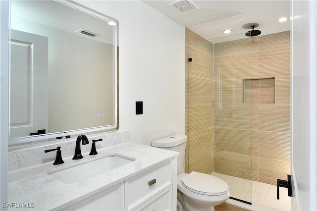 bathroom with vanity, a shower with shower door, and toilet