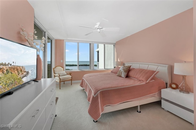 carpeted bedroom with ceiling fan and a water view