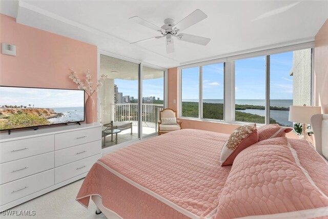 bedroom featuring ceiling fan, access to outside, and a water view