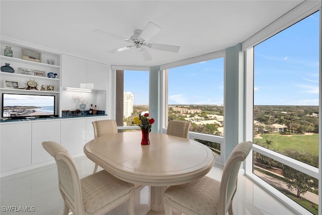 dining space with ceiling fan, tile patterned floors, built in features, and expansive windows